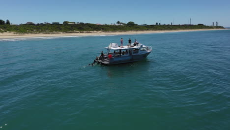Aerial-orbits-Scubabo-charter-boat-with-scuba-divers-off-sandy-beach