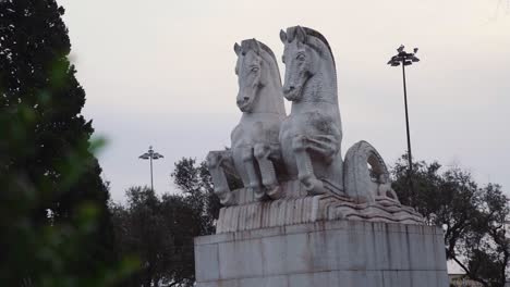 REVEAL-of-statue-of-horses-with-trees-in-foreground-and-background