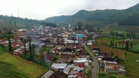 Aerial-view-of-traditional-village-surrounded-by-hills-on-Java-island,-Indonesia