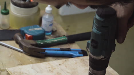 Skateboard-Maker-Drilling-Holes-On-Wood-Plank-Using-A-Cordless-Driller