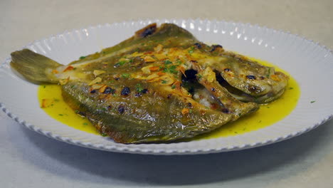 Grilled-turbot-with-garlic-and-butter-sauce,-lemon-and-aromatic-herbs