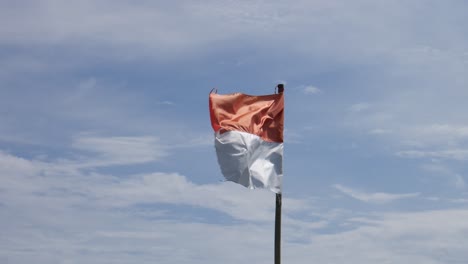 Indonesische-Flagge-Auf-Dem-Fahnenmast-Vor-Dem-Blauen-Himmelshintergrund