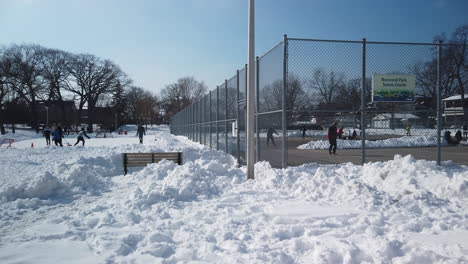 Wide-shot-of-Norwood-Park-with-people-playing-hockey-and-winter-tennis