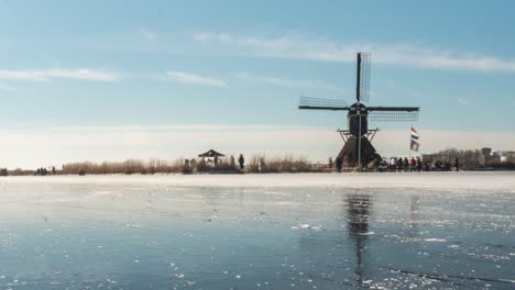 Lapso-De-Tiempo-De-Patinadores-Sobre-Hielo-En-Canal-Congelado-En-Países-Bajos,-Paisaje-De-Invierno