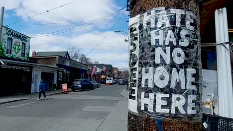 Hate-Has-No-Home-Here-poster-taped-to-a-post-in-Kensington-Market,-Toronto