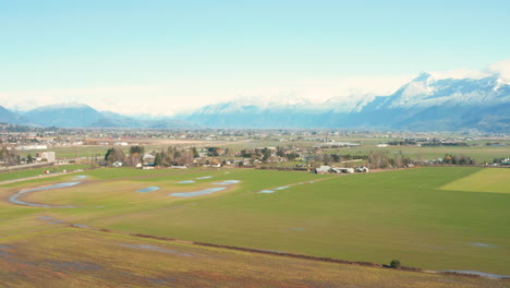 Panoramic-aerial-view-of-farmland-and-mountains