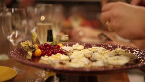 Woman-drips-sweet-honey-on-a-tray-of-cheese-and-berry-appetizers-at-a-cocktail-party---isolated