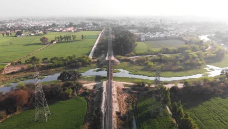 Un-Puente-Ferroviario-Que-Cruza-Los-Campos-Verdes-Y-El-Pequeño-Canal.