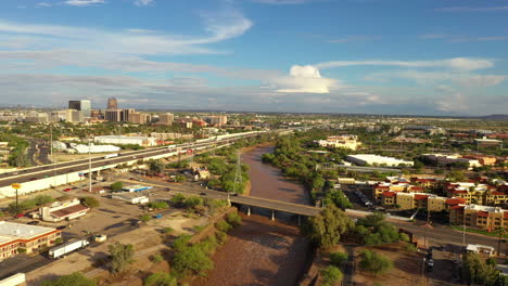 Aerial-View-Of-Raging-Santa-Cruz-River-And-Busy-Roads-In-Tucson,-Arizona-On-A-Sunny-Day-After-Monsoon