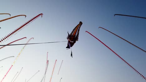 Giant-dragon-shaped-kite-flying-at-Parangkusumo-Festival,-Yogyakarta,-Indonesia