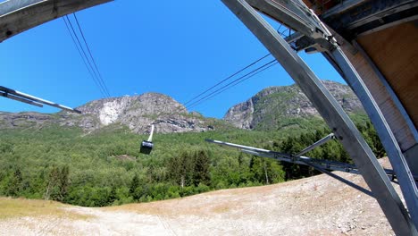 Gondola-cabin-arriving-ground-station-at-Loen-Skylift---Static-handheld-shot-looking-upwards-from-ground-station-to-top-of-Mountain-Hoven---Norway-summer