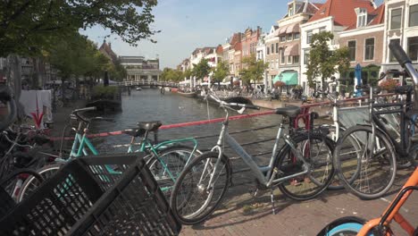Bikes-parked-on-bridge-over-Leiden-city-river,-quintessential-Dutch-urban-scene