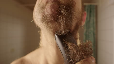 SLOW-MOTION,-WIDE,-a-man-in-bathroom-shaves-into-the-lens-with-clippers