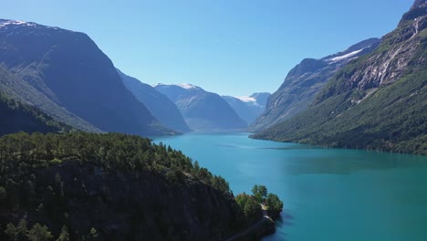 Lovatnet-freshwater-lake-with-fairytale-like-surroundings---turquoise-colored-glacier-water-and-majestic-mountains---Forward-moving-summer-aerial-Loen-Norway