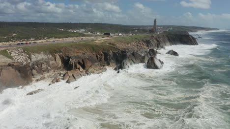 Aerial-of-rocky-cliffs-with-big-waves-coming-from-the-sea-hitting-rocks