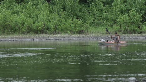 Man-In-A-Boat-Paddling-On-Calm-River-During-Summer