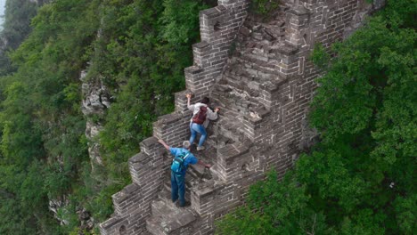 Tourist-climbing-up-a-steep-rural-section-of-Great-Wall-of-China-under-a-Guide-supervision
