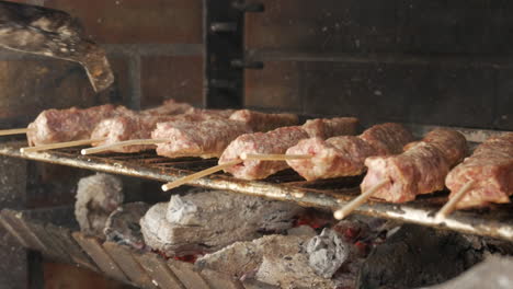 Macro-De-Un-Chef-Girando-El-Kebab-De-Carne-Rumano-En-La-Parrilla-Con-Una-Pinza