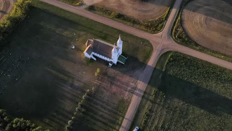 Aerial-shot-of-roman-catholic-church-in-north-American-prairie-during-sunset