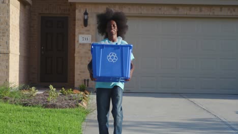 African-American-adolescents-with-huge-Afro-smiling-as-he-hold-recycle-bin-full-of-plastic-bottles
