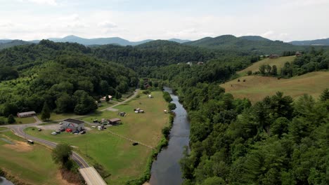 Flying-Over-the-New-River-in-Ashe-County-NC-near-West-Jefferson-and-Boone-NC,-Railroad-Grade-Road-in-Foreground