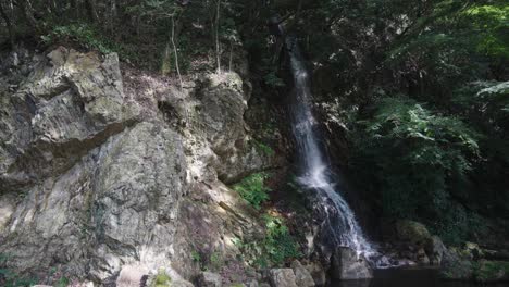 Small-waterfall-flowing-from-Mt-Kinka,-Gifu-Koen-Japan