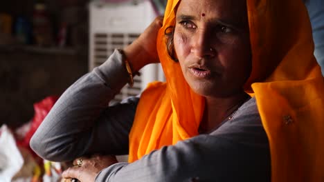 Porträt-Einer-Authentischen-Indischen-Frau-Mittleren-Alters-Mit-Gelb-orangefarbenem-Sari,-Die-Spricht-Und-Lächelt,-Rajasthan