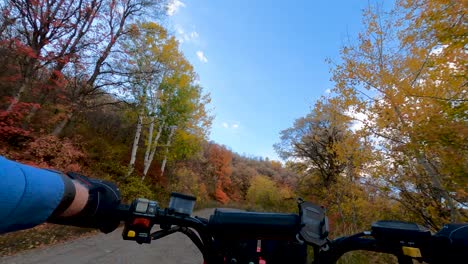 Riding-a-four-wheeler-off-road-vehicle-along-a-mountain-road-at-autumn---first-person-view