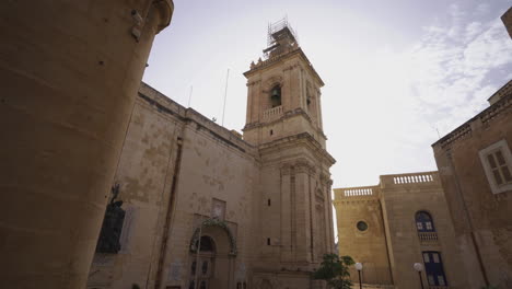 Dolly-forward-tilt-up-shot-of-church-in-old-town-Valletta,-Malta