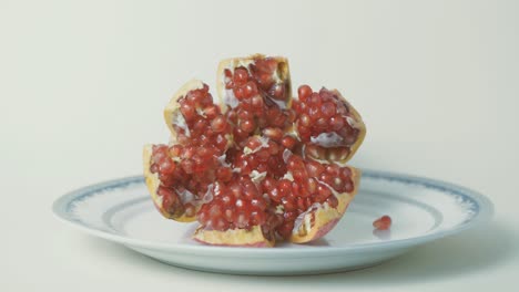 Delicious-looking-pomegranate-placed-on-plate-showing-vibrant-red-seeds