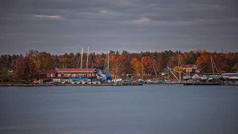 Time-lapse-shot-of-grey-flying-clouds-over-sailing-boat-harbor-during-sunset-in-the-evening---Tranquil-water-of-lake-during-autumnal-day