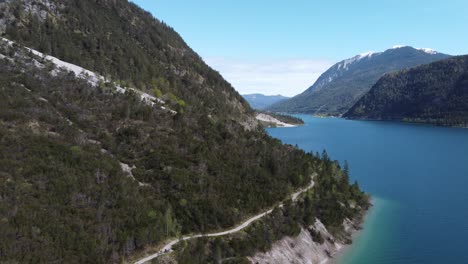 Aerial-view-of-beautiful-mountain-trail-along-a-lake-coast