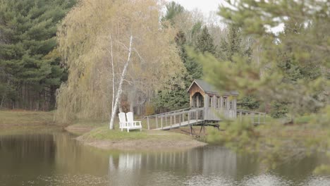 Wunderschöner-Teich-Mit-Einer-Insel-In-Der-Mitte,-Zu-Der-Eine-Holzbrücke-Auf-Der-Bean-Town-Ranch-In-Der-Nähe-Von-Ottawa-Führt