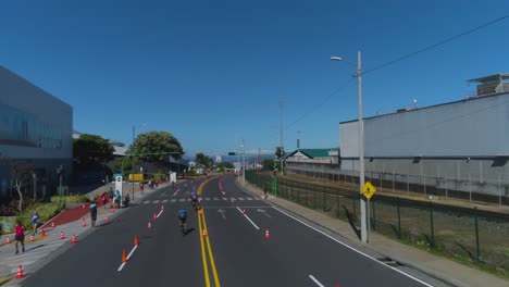 drone-shot-of-cycling-race-on-asphalt-in-city,-triathlon-competition