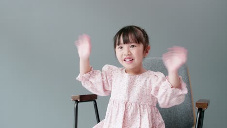 Cheerful-and-happy-child-looking-at-camera-and-swing-arms-and-pointing-to-something