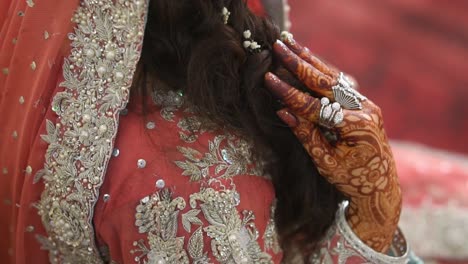 Hand-Einer-Asiatischen-Braut,-Die-Das-Haar-Berührt-Und-Ein-Rosa-Pfirsichfarbenes-Brautoutfit-Trägt