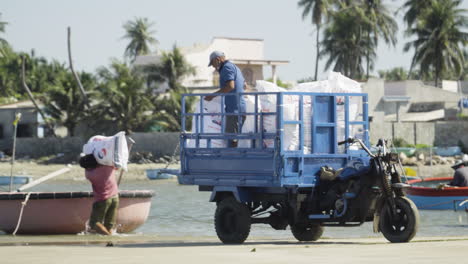 Men-at-work-unloading-materials-from-a-motorbike-to-a-little-round-boat