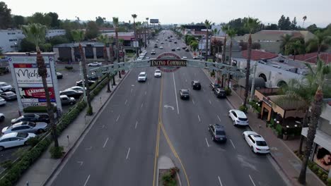 Encino-Commons-pull-back-aerial,-Ventura-Blvd-over-cars,-shopping-center-and-restaurants