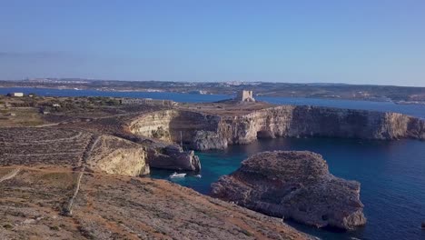 The-Blue-Lagoon-Malta-is-a-small-lagoon-with-relatively-shallow,-crystal-clear-water-that’s-located-on-the-island-of-Comino,-between-Malta-and-Gozo