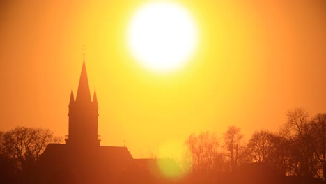 Time-lapse-of-orange-sunset-over-church-silhouette-in-Magdeburg,-Germany
