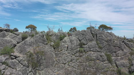 Student-slowly-rappels-steep-rugged-rock-of-Sugarloaf-mountain,-VIC