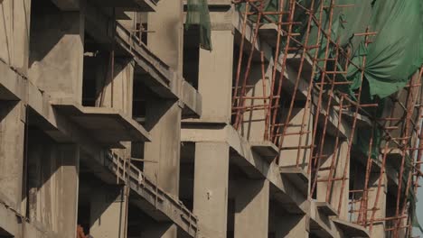 Scaffolding-On-Building-Construction-Site-In-Karachi-With-Wind-Blowing-Green-Sheeting-On-Side