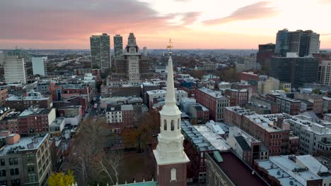 Aerial-of-Christ-Church-steeple,-revealing-Philly-skyline-at-sunset