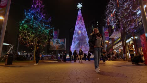 Tourists-sightseeing-around-colourful-Winterfest-LED-Christmas-tree-illuminated-art-installation-at-Wembley-park-at-night