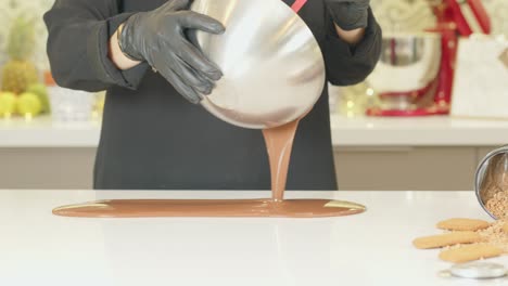 melted-chocolate-pouring-into-table-by-chef-in-black-apron