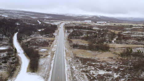 Fahrzeuge-Fahren-Auf-Einer-Winterlichen-Straße-Mit-Verschneiter-Strecke-In-Dovre,-Kreis-Innlandet,-Norwegen