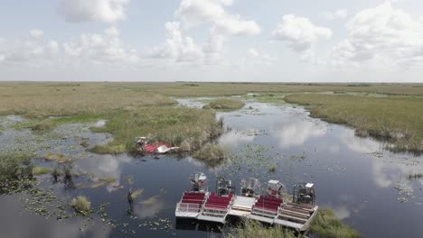 Eco-tourism-air-boats-lined-up-at-edge-of-dark-swamp-await-visitors