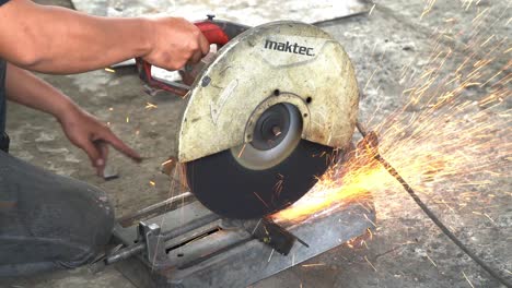 worker-cutting-metal-with-metal-cutting-machine