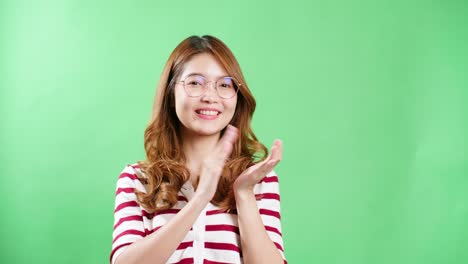 Woman-with-eyeglasses-in-studio-clapping-with-chroma-key-in-the-background