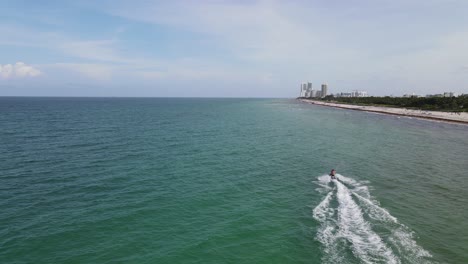 Vista-Aérea-De-La-Playa-Surfside,-Miami,-Mientras-El-Jetski-Entra-En-El-Cuadro-Desde-Abajo